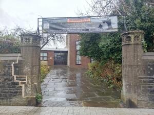 From street facing venue. Pillars on left and right. Path to entrance at centre.