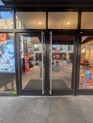 Black frame glass doors in front. Silver handle on middle. Pull to open.