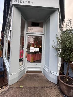 Glass door with white wooden frames ahead. Push from left to open.