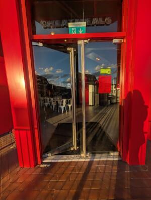 Red frame glass doors in front. Silver handle on center. Push to open.