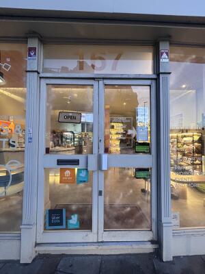 Glass doors with grey metal frames ahead. Push from center to open.