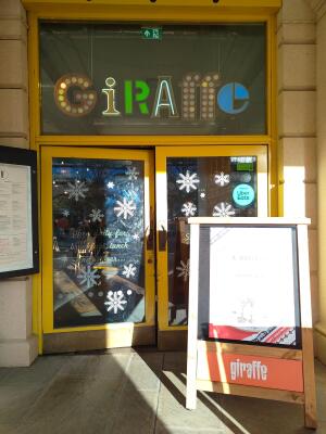 Glass doors with yellow metal frames ahead. Push from center to open. Sign board on right.