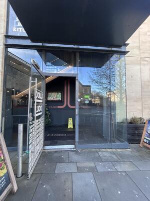 Glass door with grey frames ahead. Pull handle on right to open.
