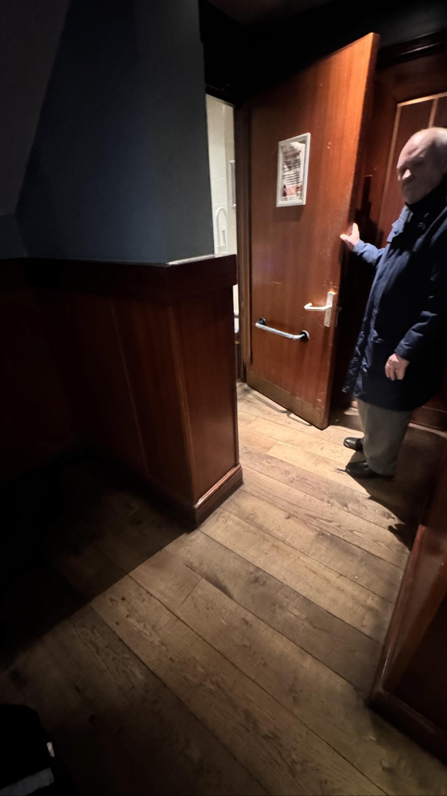 Wooden door with metal handle on right. Pull from handle on right to open.
