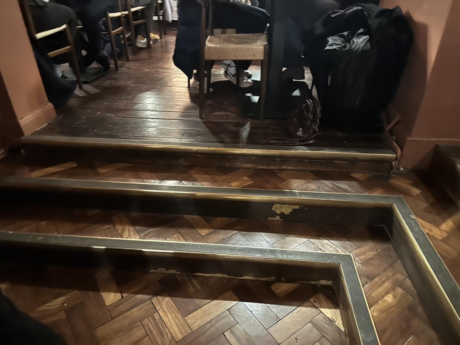 Two steps up before seating area. Steps have brass edging.