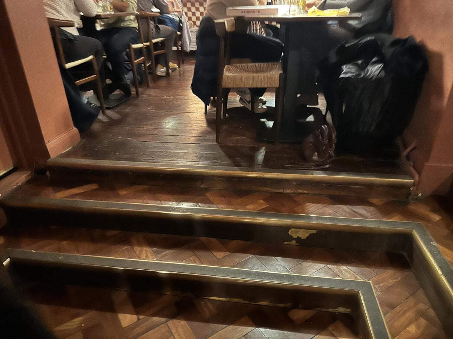 Three steps up to seating area. Tables and chairs visible ahead.