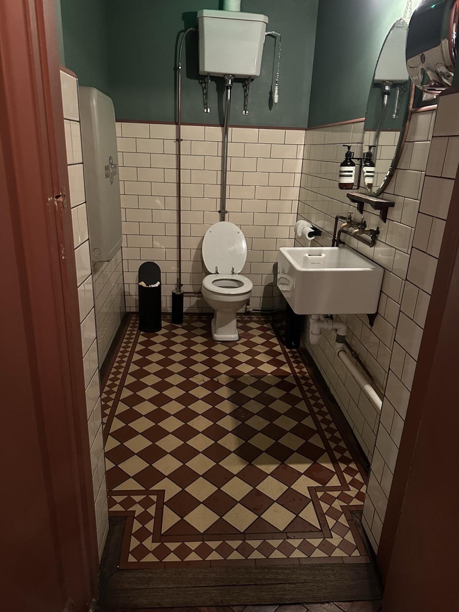 Baby changing station left. Toilet at back wall. Sink on right wall.