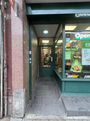 Green framed archway ahead to entrance at back.