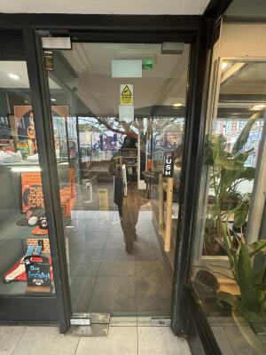 Black framed glass doors ahead. Push wooden handle on right to open.