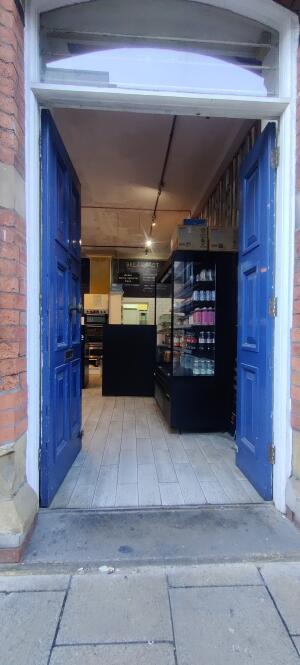 Blue wooden door ahead. Push metal knob along up center.