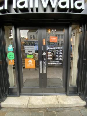 Black framed glass door. Push silver metal handle from centre to open.