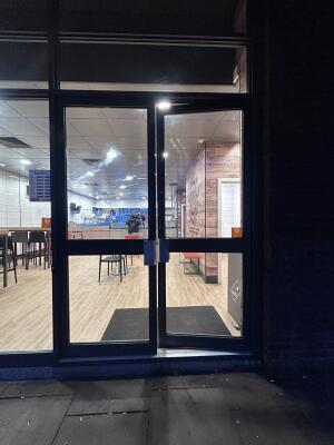 Glass doors with grey metal frames ahead. Push from center to open.