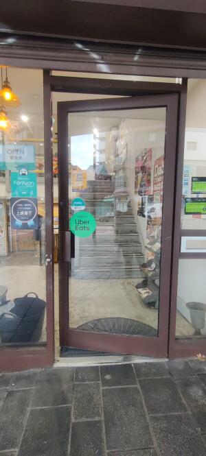 Brown metal framed glass door ahead. Push handle at left.