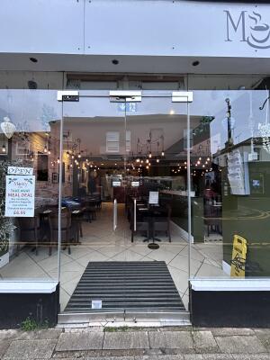 Glass doors with glass frames ahead. Push from center to open.
