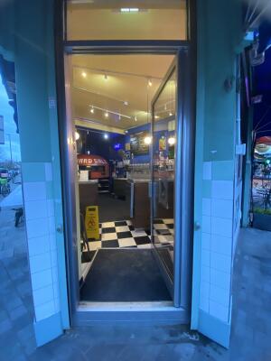 Silver framed glass door. Push from left to open.
