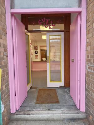 Pink wooden door ahead. Push from handle at centre to open.