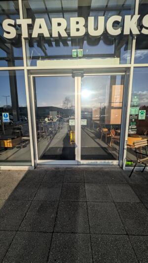 Glass automatic sliding doors. Doors slide open to left and right from centre.