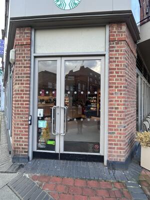 Glass doors with grey metal frames ahead. Pull from center to open. Door bell on left of frame.