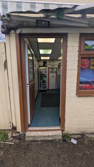 Brown wood-framed glass door. Push from handle on right to open.
