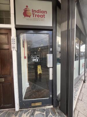 Black metal-framed glass door. Push from metal handle on right to open.