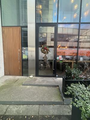 Black framed glass door at back. Push handle on right to open.