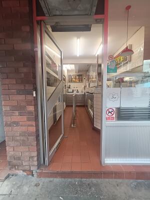 Grey metal-framed glass door. Push from handle on right to open.
