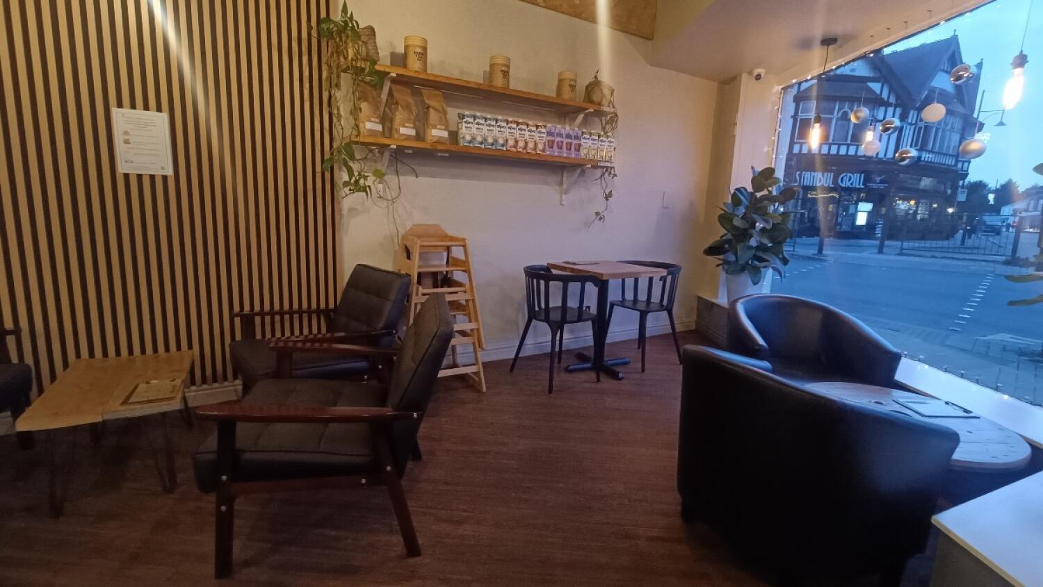 From entrance facing right. Armchairs and tables on both sides. Table and chairs at back.