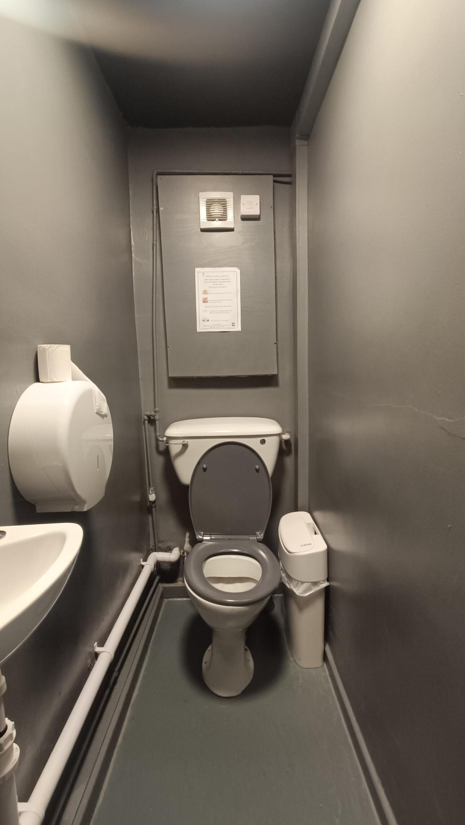 From archway facing right. Sink on left. Toilet at back.