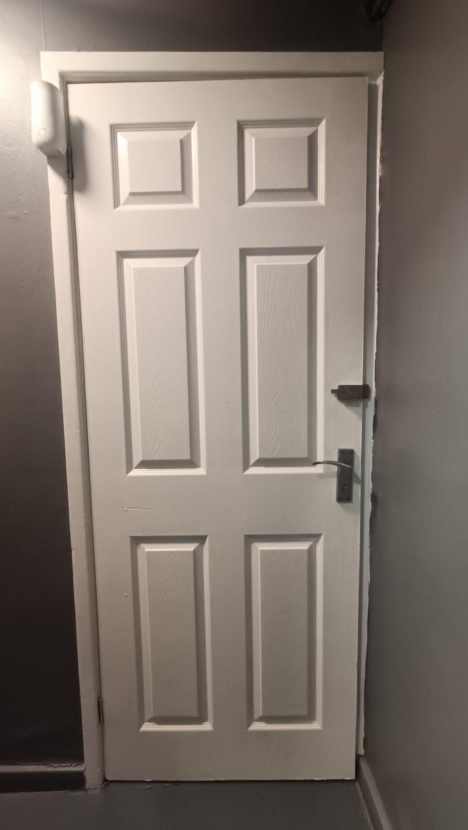 Back of toilet door. Lock on right. Pull handle on right to open.