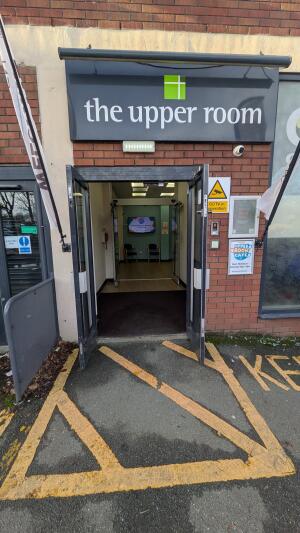 Black metal-framed glass doors. Pull from handles at centre to open.