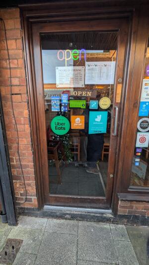 Brown wood-framed glass door. Push from metal handle on right to open.