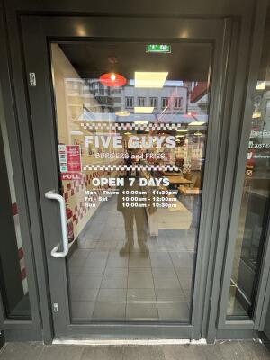 Grey framed glass door ahead. Pull handle on left to open.