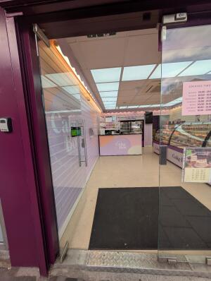 Glass door in front. Silver handle on right. Push to open.