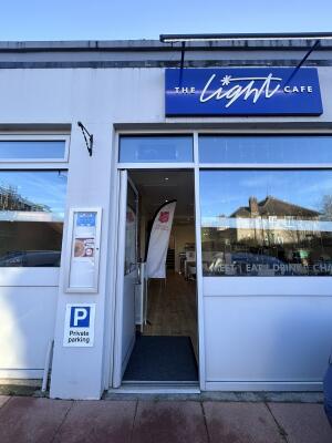 Glass door with grey wooden frames ahead. Push from right to open.