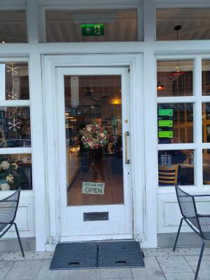 Glass door with white wooden frames ahead. Push from right to open.