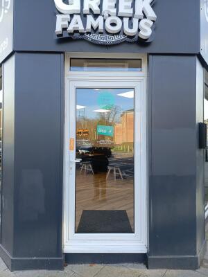 Glass door with white frame ahead. Push from handle on left to open.