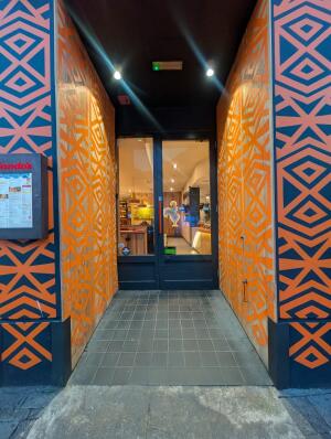 Orange archway in front. Black frame glass door at back. Red handle on left. Pull to open.