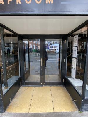 Black framed glass door. Pull gold metal handle from centre to open.