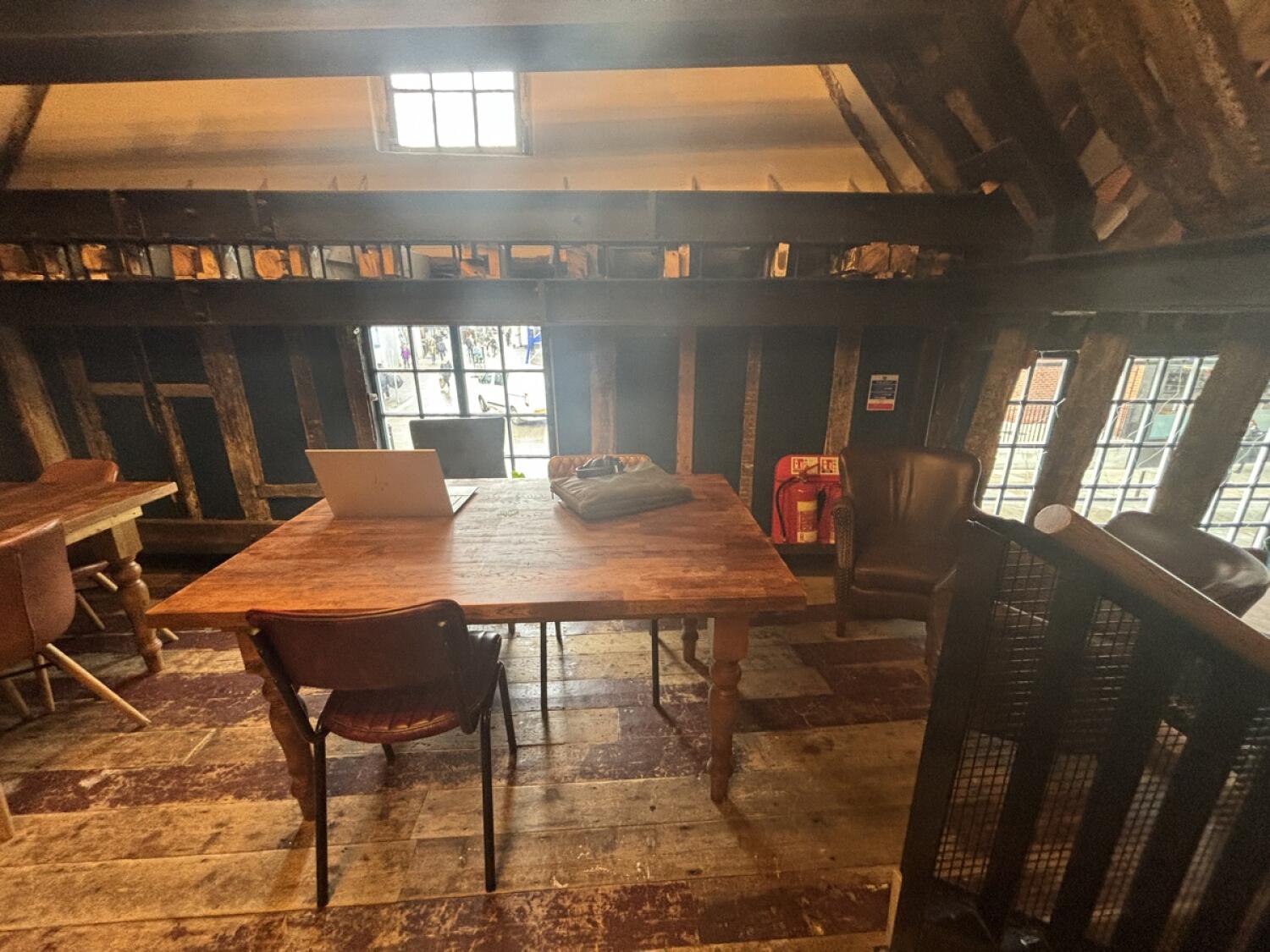 From top of steps facing right. Tables and chairs ahead. Armchairs and low tables at back right.