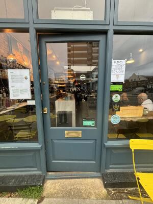 Grey framed glass door ahead. Push from left to open.