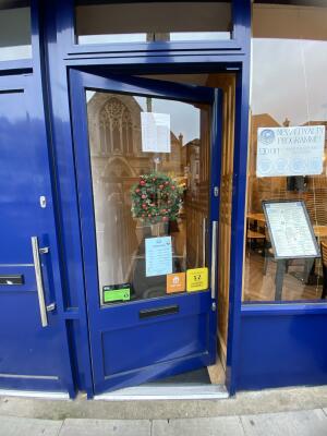 Blue framed glass door. Push silver metal handle from right to open.