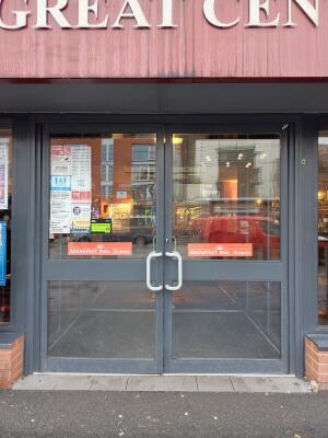 Double glass door with grey frame ahead. Pull from handle at centre to open.