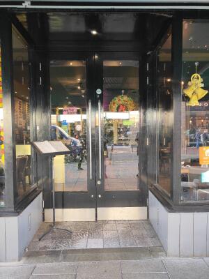 Black framed archway ahead. Black framed double glass doors at back. Pull silver handle in centre to open.