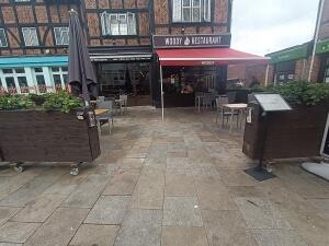 From entrance, facing straight. Planters ahead on both sides. Seating behind. Path ahead to entrance door.
