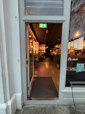White wood-framed glass door. Push from handle on right to open.