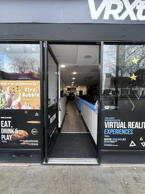 Glass door with black metal frames ahead.  Push from right to open.