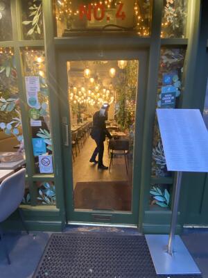 Green framed glass door. Push silver metal handle from left to open. Menu to the right of door.