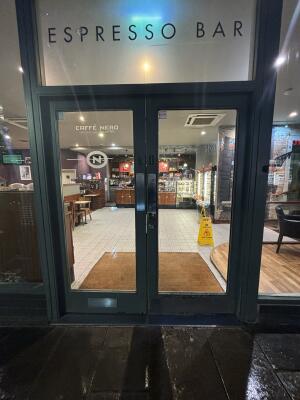 Black framed glass doors ahead. Push from centre to open.