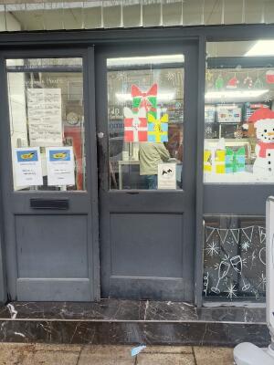 Glass door with black frame ahead. Push from left to open.