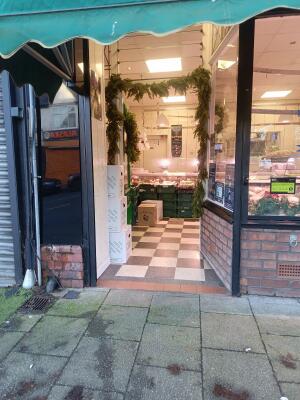 Glass door with green frame ahead. Push from handle on left to open.